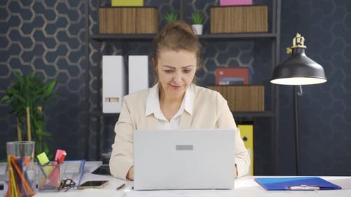 Woman Working on Laptop in Office Setting