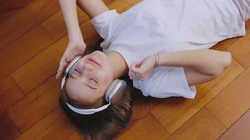 Woman Relaxing on Floor Listening to Music