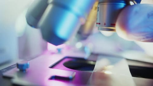 Scientist Adjusting Microscope Lenses for Precise Analysis