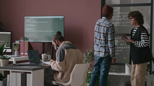 Diverse Programmers Discussing Algorithm ding by Glass Panel with Code in Office