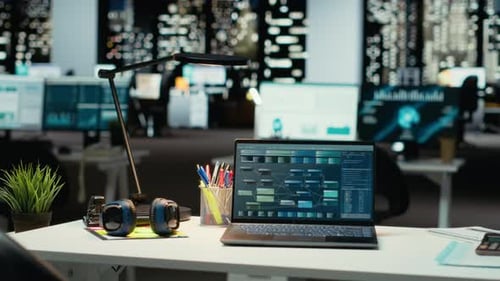 Desk with Laptop Showing Data in Empty Office