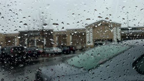 Raindrops on Car Window Obscure City Building