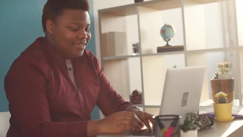 Happy Young African American Man Working on Laptop Typing in Office Smiling Sunlight Business Person