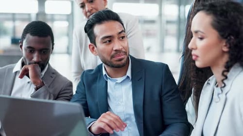 Team Discusses Solutions on Laptop in Bright Office