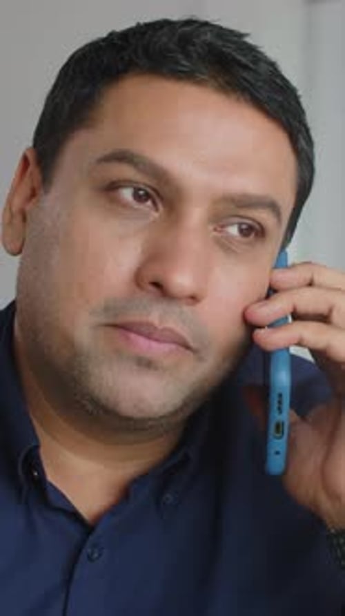 Adult with Dark Hair Talking on Mobile Phone