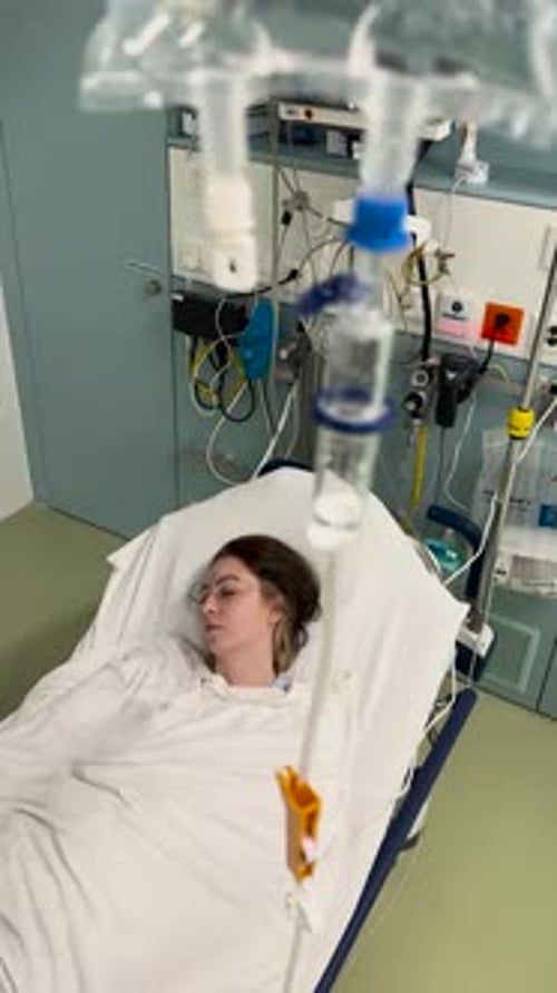 Patient with IV Drip in Hospital Bed – Medical Treatment Scene