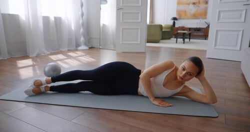 Fitness Enthusiast Performing Side Plank Exercise on Mat in Bright Modern Living Room Space