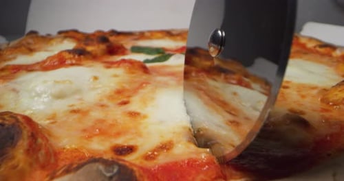 Pizza Sliced with Rolling Cutter in Close Up