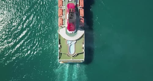 Luftaufnahme eines Containerschiffs, das in einem industriellen Seehafen eines Ziellandes angekommen ist.