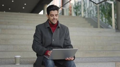 Man Celebrates Good News Working on Laptop Outdoors