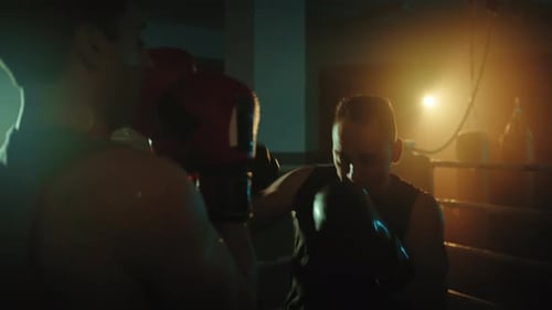Boxers Fight in the Ring at Night