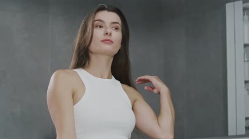 Attractive Woman Smiling in Bathroom Mirror