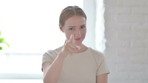 Young Woman Points Index Finger at the Camera
