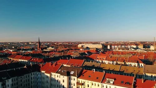 Aerial view over red roofs and sunlit buildings in the city of Leipzig, golden hour, in Germany - lo