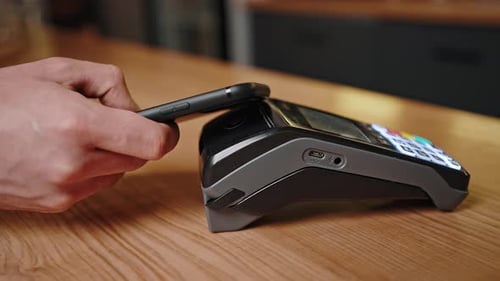 Man Puts Smartphone to Sensor on Terminal to Pay for Coffee