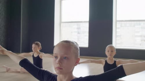 Girls Doing Exercises with Their Arms while Sitting in Splits