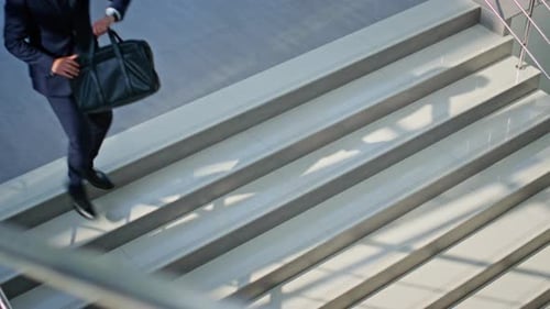 Employee Running Down Stairs Sunlit Building in Elegant Suit Man Executive