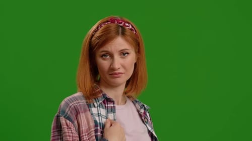 Perplexed female is pointing herself and says who me no thanks over green screen background.