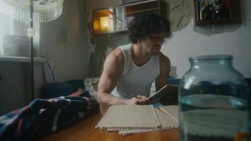 Male Poet Composing Poems in Shabby Home