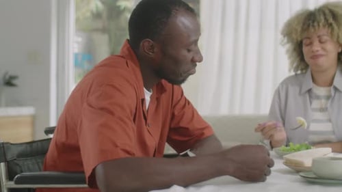 Couple Conversing at Dining Table, Man in Wheelchair