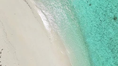 Zoom Out Top View of Tropical Beach with White Sand and Clear Turquoise Water in Natural Sunlight