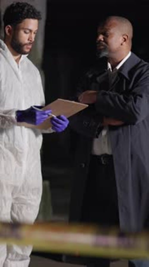 Investigator Talks With Forensic Specialist at Crime Scene