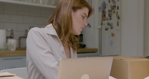 Woman Sorting Paperwork With Laptop And Boxes