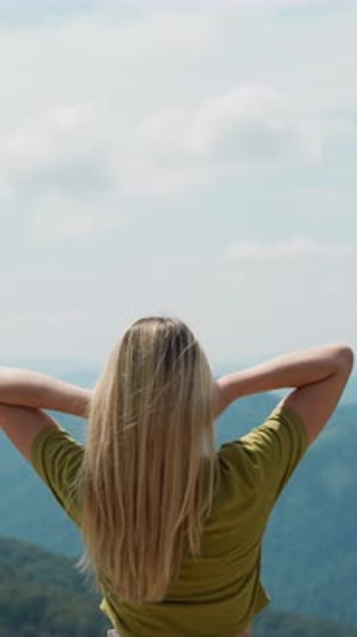 Graceful Tourist Puts Hands Up Against Mountainous Valley