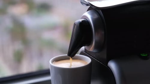 Close up of a coffee machine pouring an expresso in a cup.