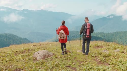 Back View of Hikers Man and Woman Tourists Going to Mountain Peak in Valley