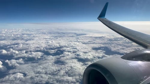 A Veil Of White And Fluffy Clouds View From Window Of A Flying Airplane. Aerial