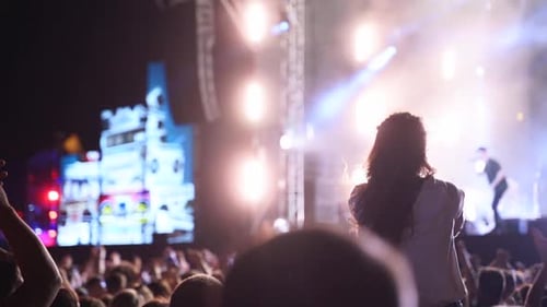 Energetic Crowd Enjoys Live Music Performance at Night