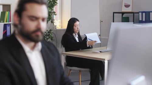 Woman Reviews Documents at Modern Office Workplace