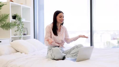 Glückliche Frau winkt Hallo, während sie per Videoanruf mit modernem Laptop spricht