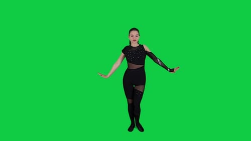 Young woman dancing on a green screen background. Girl makes a gesture with her hands as if banging
