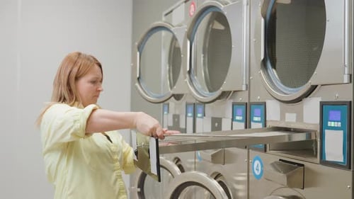 Le propriétaire de la blanchisserie verrouille le tiroir du filtre de la machine à laver après le nettoyage