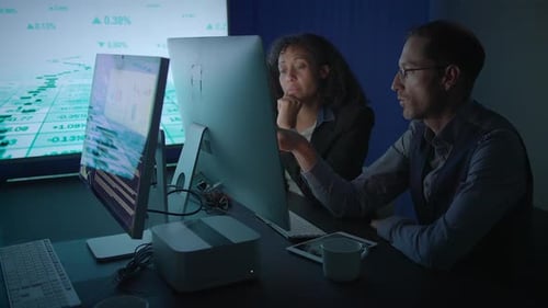 Business Professionals Engaging in Detailed Data Analysis Within a Contemporary Office Environment