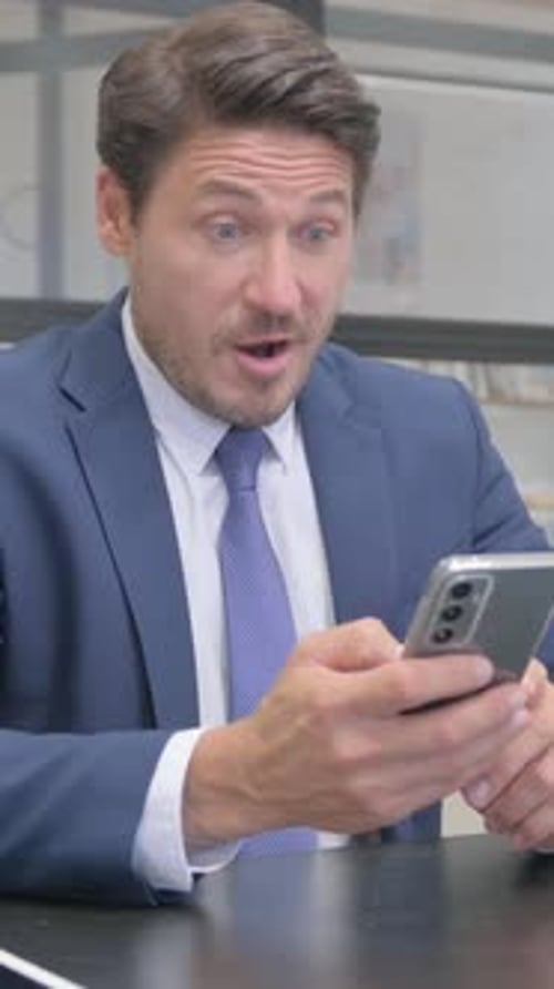 Excited Businessman Celebrating Success on Smartphone Device