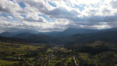 Sun Rays Break Through the Clouds Over Ukrainian Village Aerial View of Scenic Carpathian Landscape