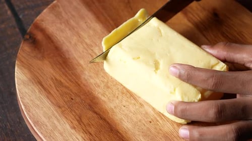 Cutting Butter with a Knife on Chopping Board