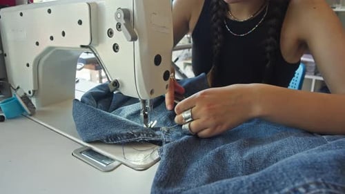 Skilled Seamstress Has Finished Sewing Seam on Sewing Machine at Factory Now She is Using Scissors