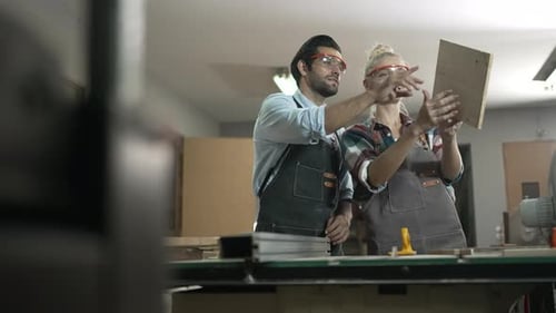 Carpenters are working together at workshop.