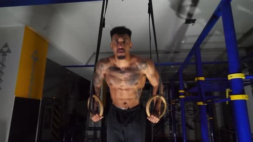 Muscular Afro American Sportsman Doing Push Ups on Gymnastic Rings at Gym Strong African Athlete