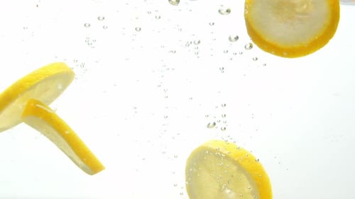Lemon Slices Falling into Clear Water