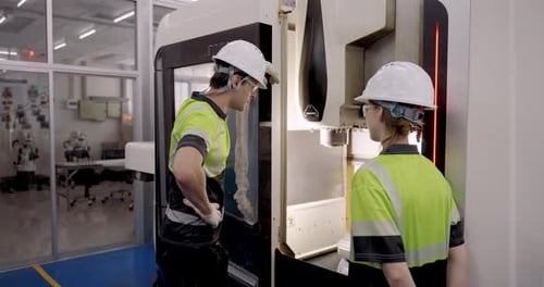 technicians opening cnc machine panel during slowmotion automation training focusing on internal