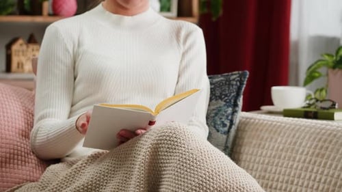Frau blättert in deutschsprachigem Buch, Lesen und Lernen, blättert in altem Lehrbuch