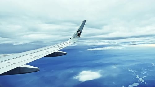 Voo
de avião. Asa de um avião voando acima das nuvens. Vista da janela do avião