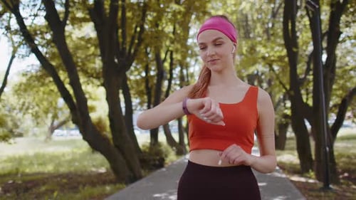 Woman Checks Smartwatch in Sunny Park