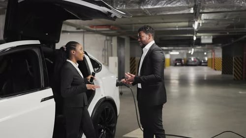 Business People Sealing Deal with Handshake in EVs Parking