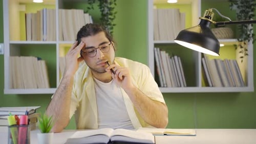 Männlicher Student, der vom Lernen verwirrt ist.